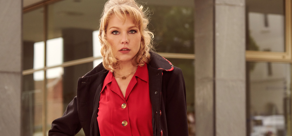 Frau in rotem Kleid und schwarzem Mantel im Vintage-Stil