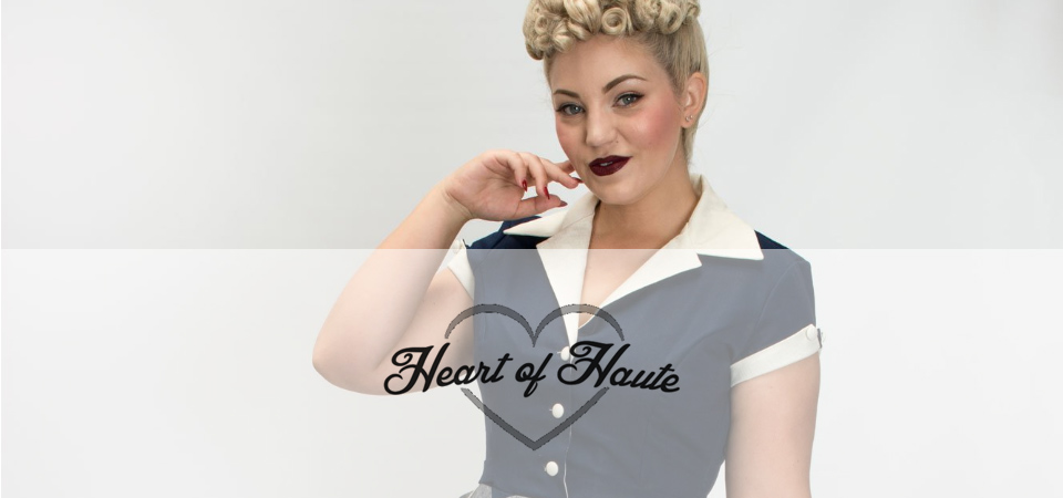 Frau mit Poodle-Frisur in einem blauen 50er Jahre Kleid mit weißem Kragen, Logo der Marke Heart of Haute