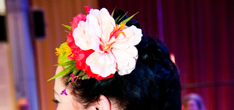 Kopf einer Frau mit einer Orchideen-Haarblume im Haar