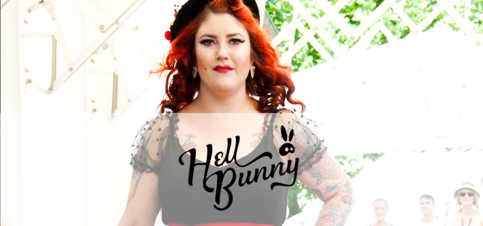 Frau in einem schwarzen Oberteil mit Tüllärmeln, Logo der Marke Hell Bunny