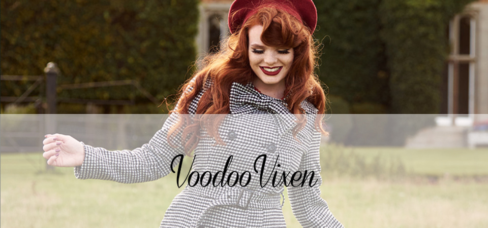 Eine Frau in einem Tweedmantel steht auf einer Wiese, Logo der Marke Voodoo Vixen